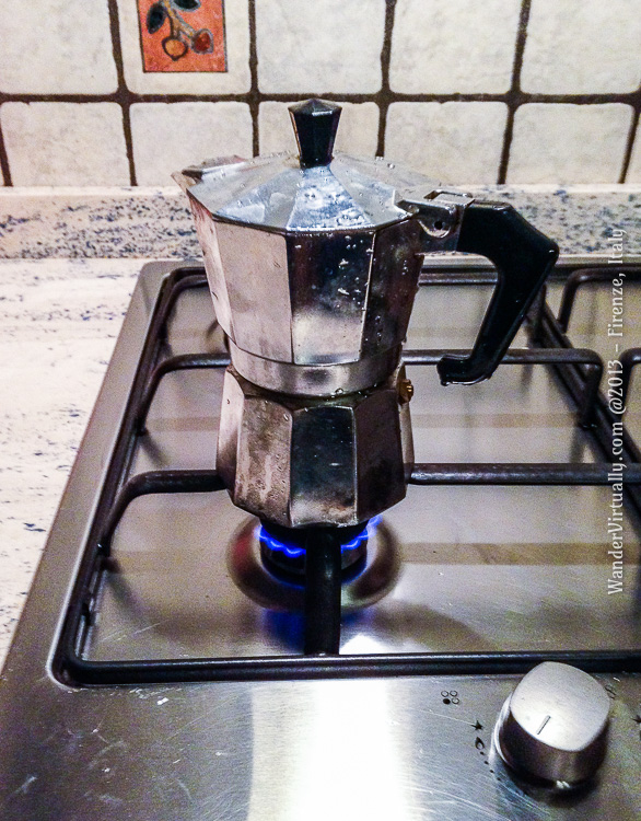 Preparing homemade caffe espresso the Italian way - a Bialetti moka pot on a stove.