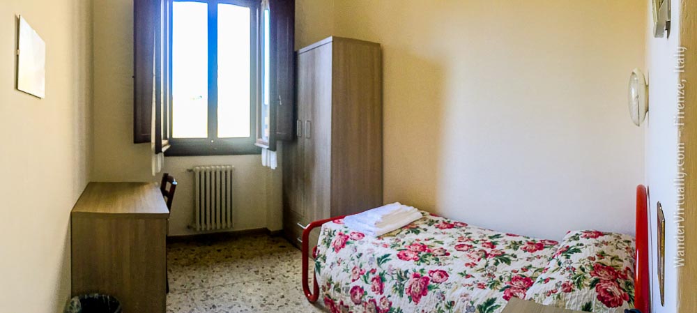 Convents & Monasteries in Florence. A simple room with a single bed, wardrobe, desk, and chair at Casa Regina del Santo Rosario. Firenze, Italy.